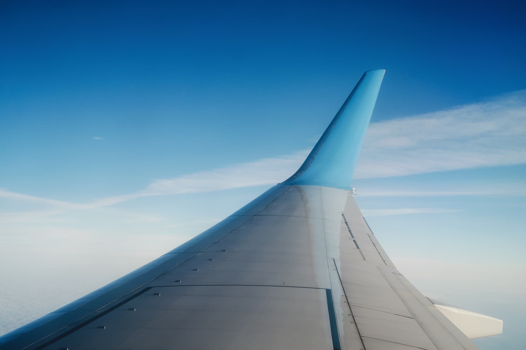 View From Airplane Window With Blue Bright Sky In The Background