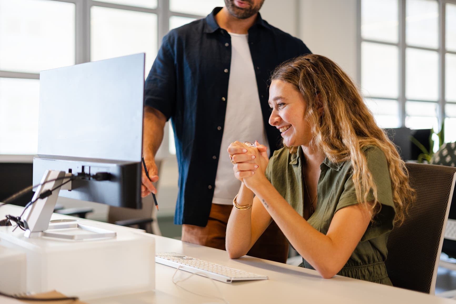Businesspeople working together using computer in modern workplace.